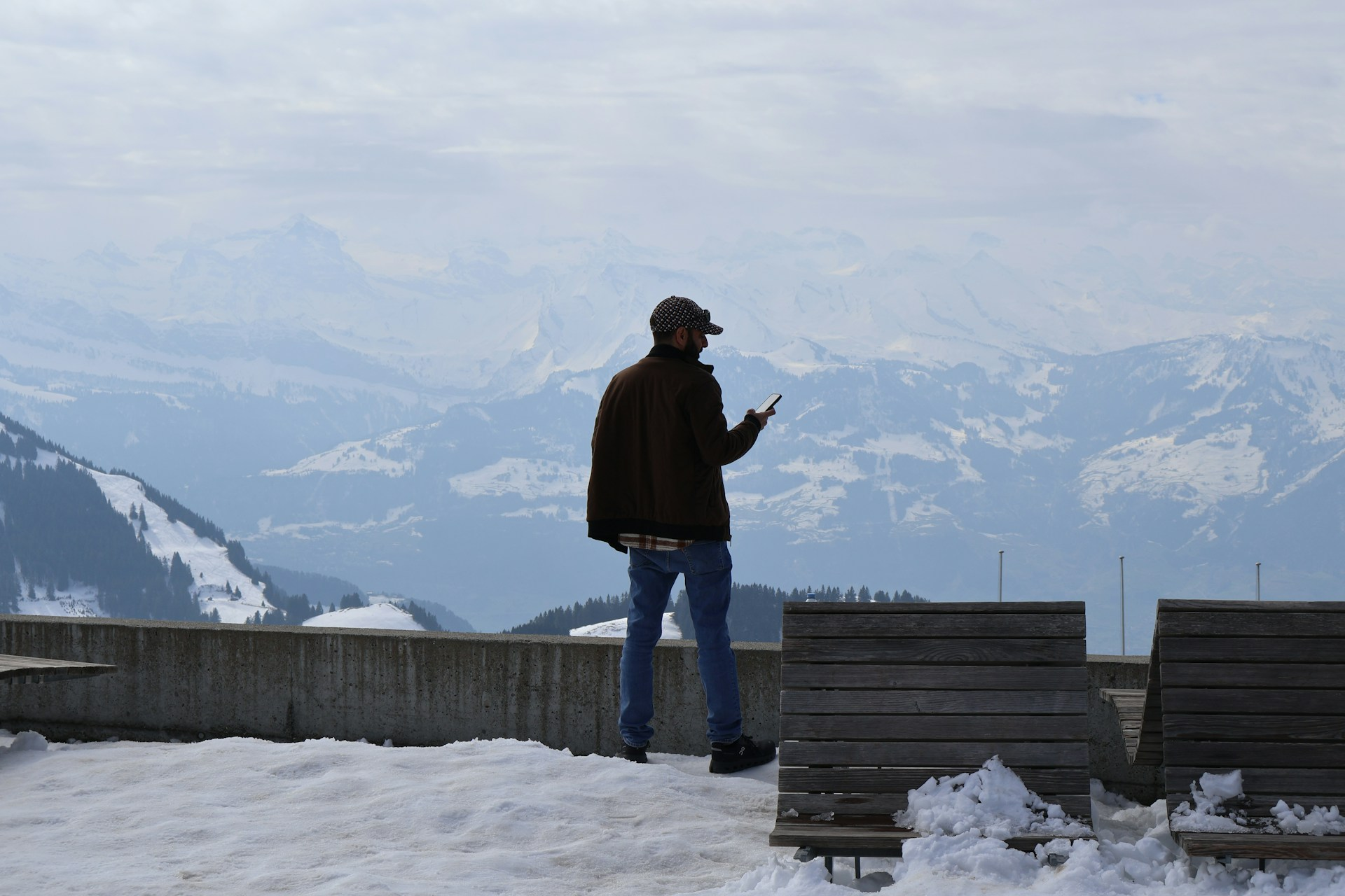 Photo : personne consultant son téléphone face aux montagnes
