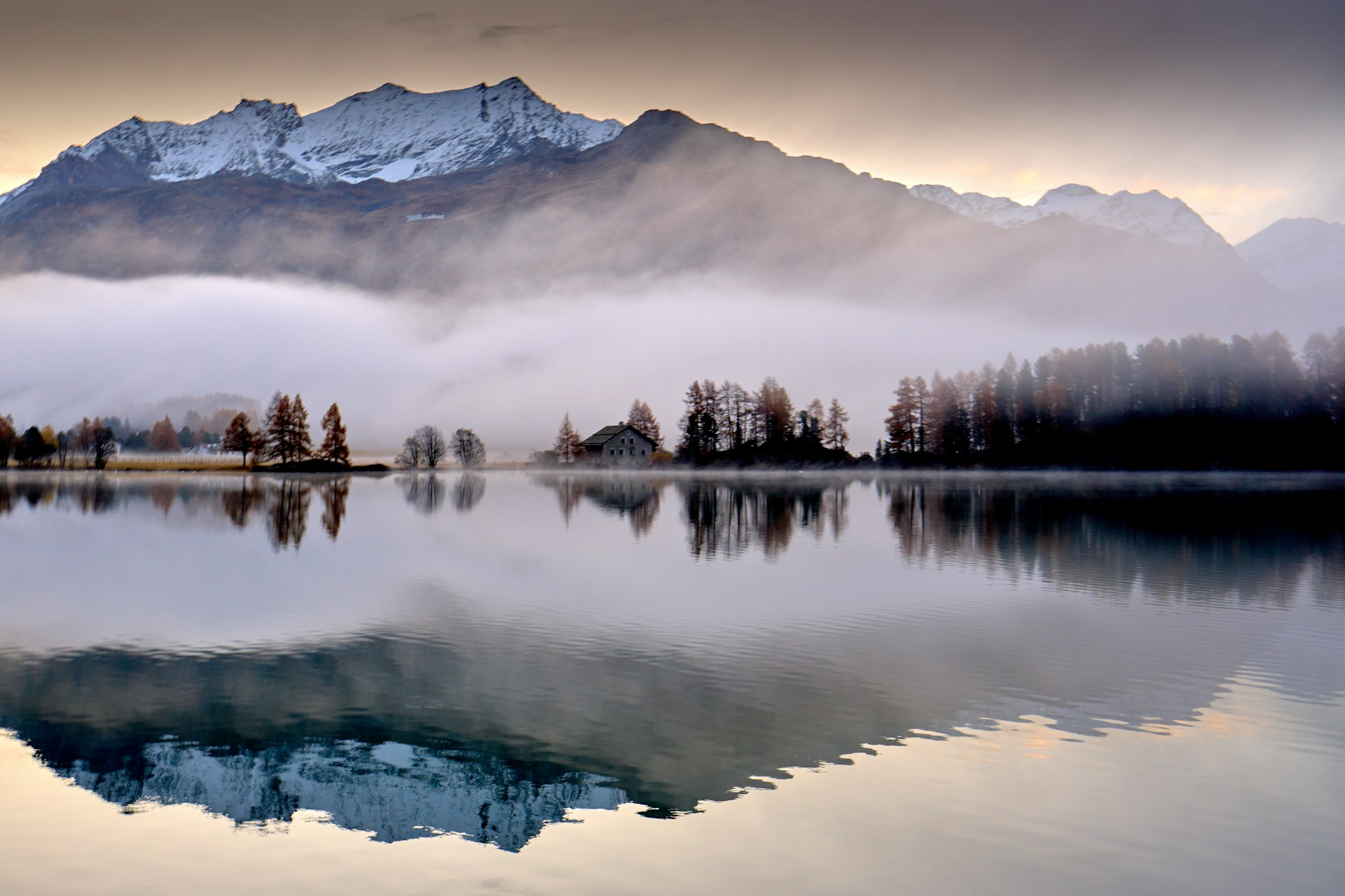 Photo : lac de montagne calme reflétant des sommets au petit matin